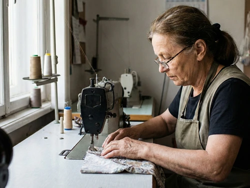 Experienced seamstress carefully stitching a custom cushion on industrial sewing machine