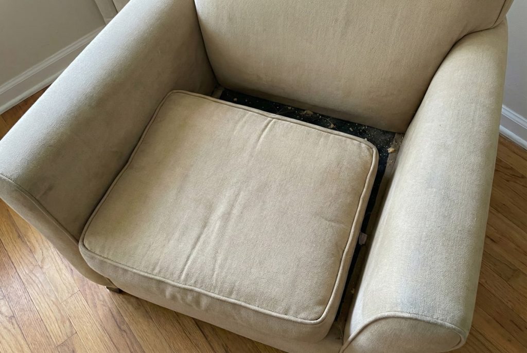 Gap between poorly fitting cushion showing accumulated debris