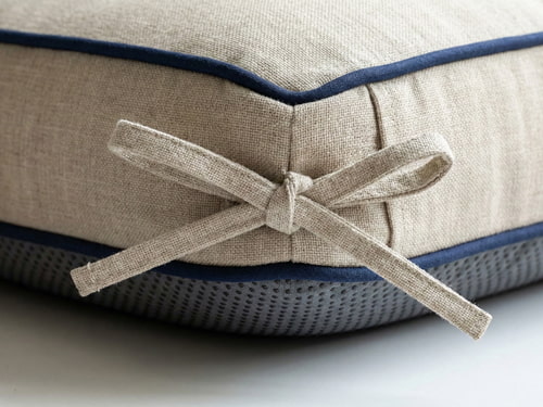 Outdoor cushion features including ties, non-slip bottom, and piping details